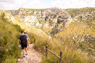 Rear view of man walking on mountain