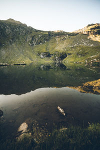 Scenic view of lake by mountain against sky
