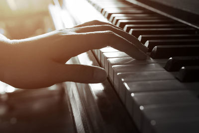 Cropped hand of playing grand piano