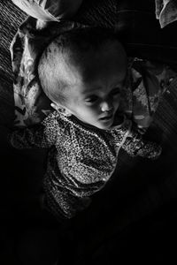 Boy with large head sleeping on bed at home