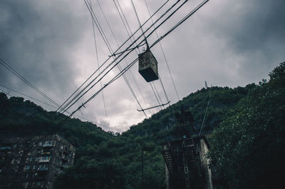 Low angle view of overhead cable car against sky