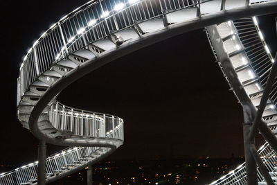 Low angle view of illuminated bridge against sky at night