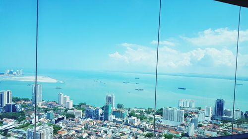 High angle view of cityscape by sea against sky