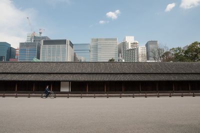 Street by buildings against sky