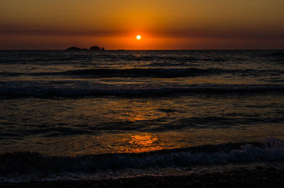 Scenic view of sea against orange sky