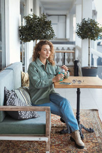 Full length of woman sitting at cafe