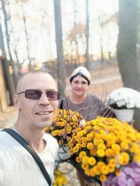 Portrait of smiling man and woman by flower plants