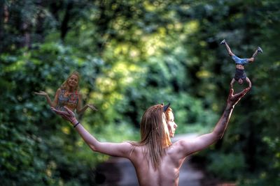 Rear view of woman with arms raised