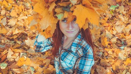 Portrait of young woman with autumn leaves