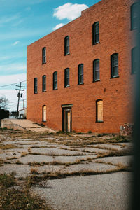 Building by street against sky in city