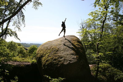 Low angle view of man on rock against sky