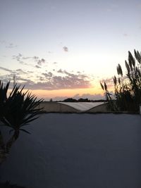 Scenic view of snow covered landscape against sky during sunset