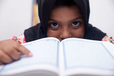 Cute muslim little girl reading koran