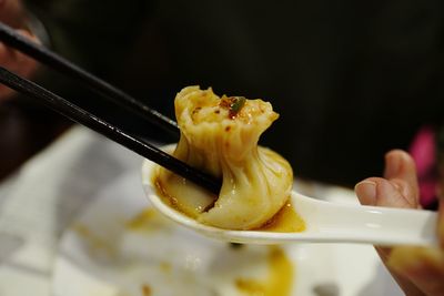 Cropped image of person holding dumpling at restaurant