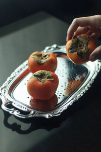 Close-up of hand holding fruit salad in plate