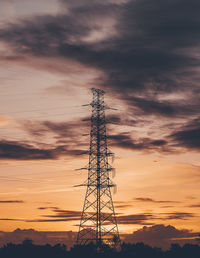 Low angle view of silhouette electricity pylon against sky during sunset