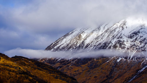 Close-up of snow covered mountain against sky