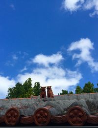 Low angle view of trees against cloudy sky