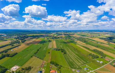 Aerial panorama from a drone of countryside, village, green fields and trees, agriculture concept.