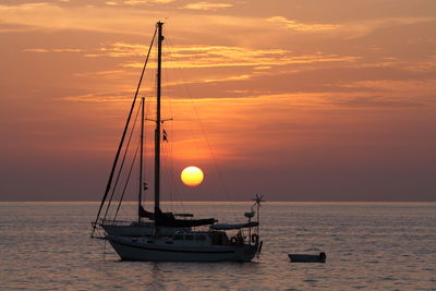 Silhouette sailboat on sea against sky during sunset