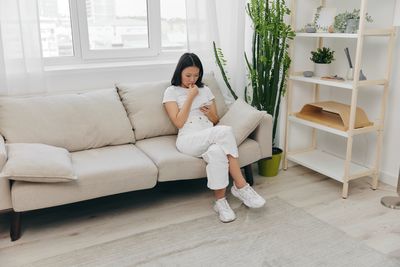 Portrait of woman sitting on sofa at home