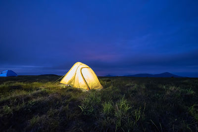 Tent on field against clear blue sky