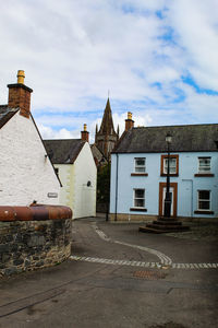 Street amidst buildings in town against sky