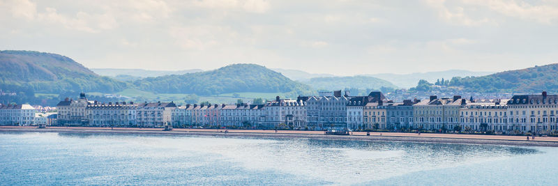 Buildings by lake against sky in city