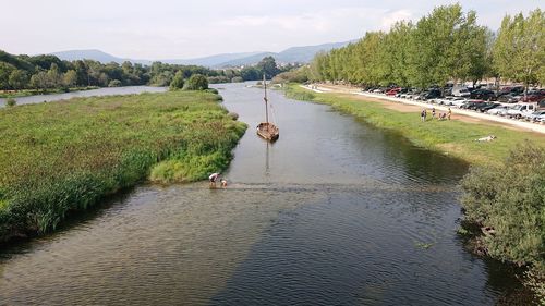 Scenic view of river by trees against sky