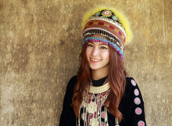 Portrait of smiling woman against wall