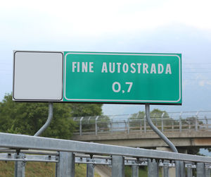 Road sign against sky