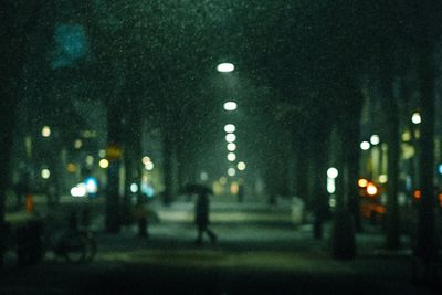 Defocused image of person walking on road at night