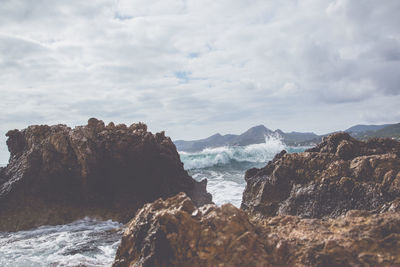 Rock formations by sea against sky