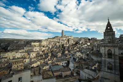 Buildings in city against cloudy sky