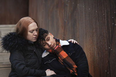 Young woman hugging and comforting boy