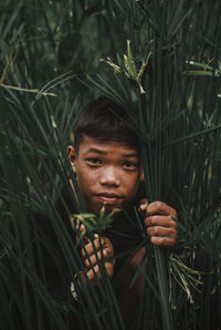 Portrait of man standing against plants