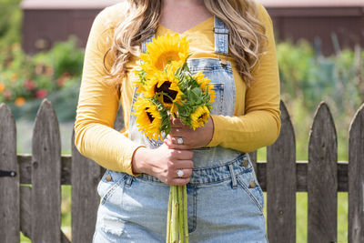 Midsection of woman holding flower bouquet