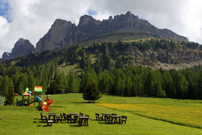 People walking on field against mountains