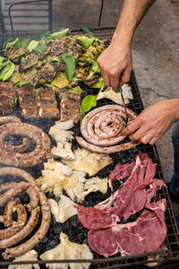 Hands on barbecue. close up on hands moving the meal on the grill.