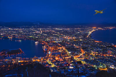 Aerial view of illuminated cityscape against sky at night