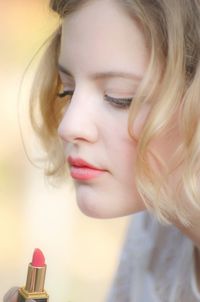 Close-up of woman holding lipstick