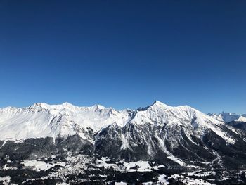 Scenic view of snowcapped mountains against clear blue sky