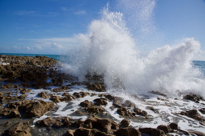 Water splashing on rocks against  vivid blue sky