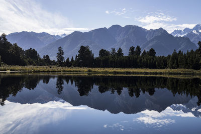 Scenic view of lake by mountains against sky