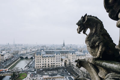 Close-up of statue in city against sky