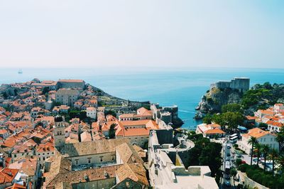 Cityscape by sea against clear sky