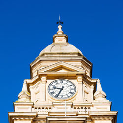 Low angle view of clock tower against blue sky