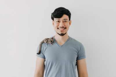 Portrait of smiling young man against white background