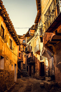 Low angle view of alley amidst buildings against sky