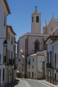 Low angle view of street amidst buildings against clear sky